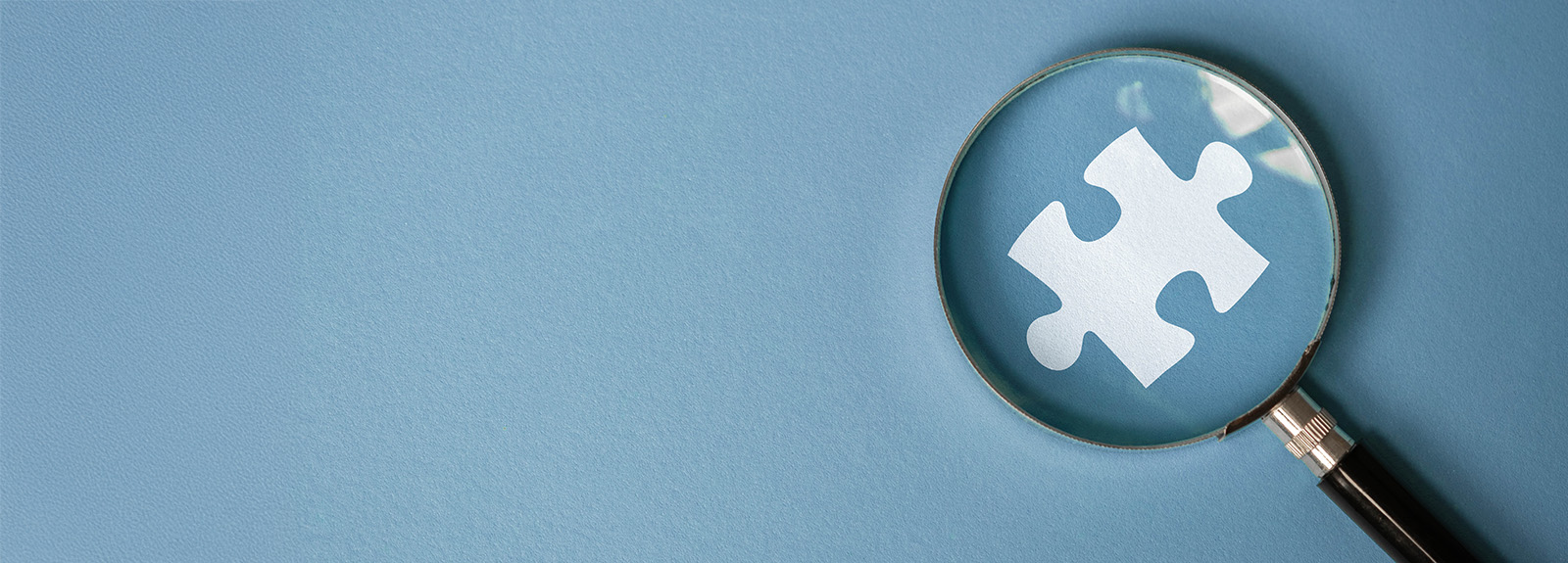 A magnifying glass looking at a puzzle piece